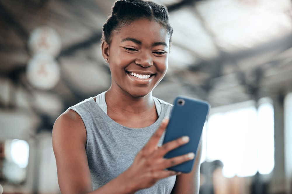 Young woman looking at her phone smiling